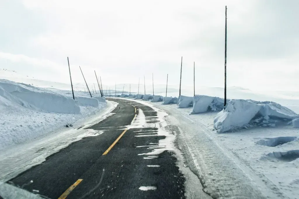 A road covered with patches of black ice in the winter.