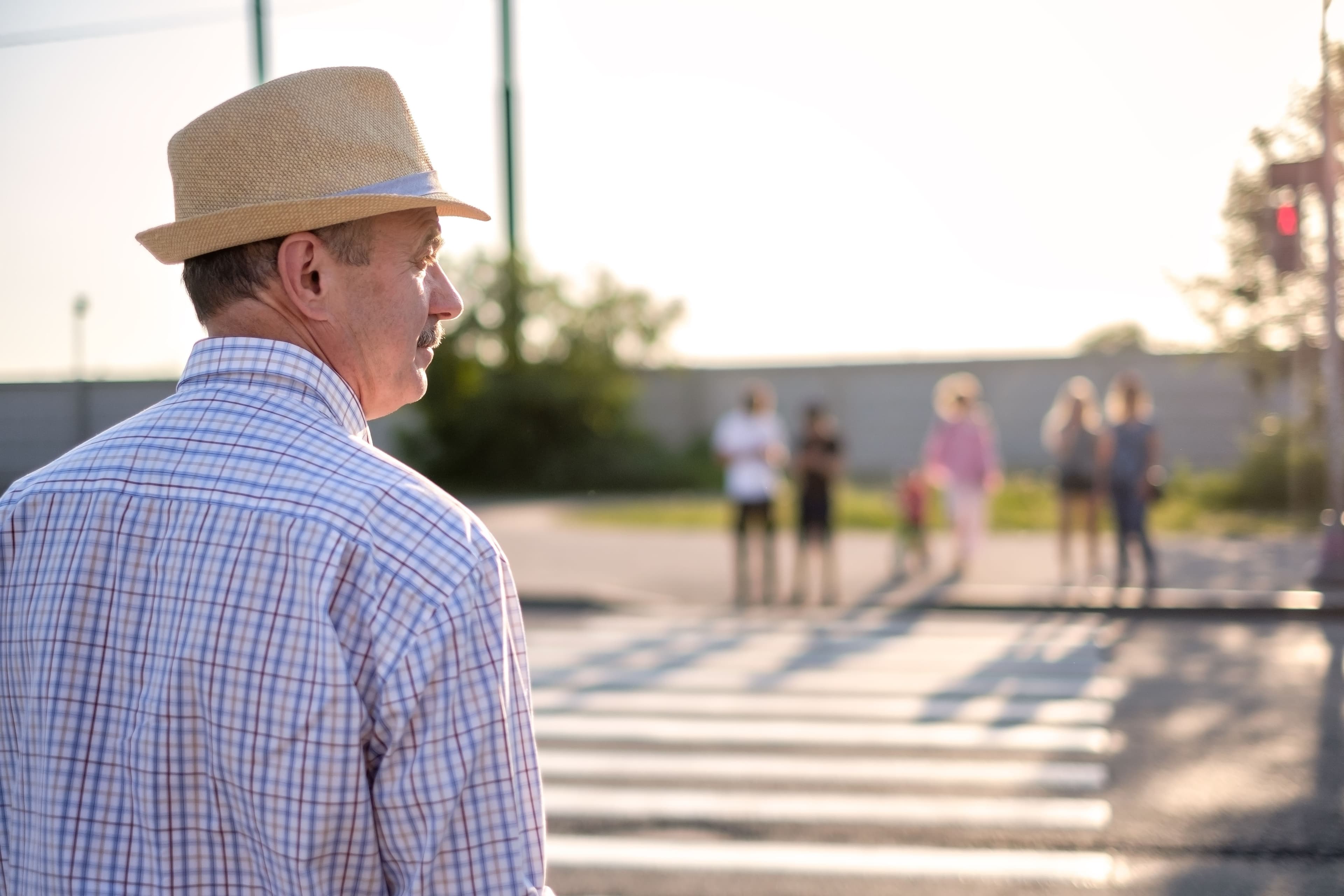 A man waits to cross the street at a crosswalk, abiding by Oregon's crosswalk laws for pedestrians.