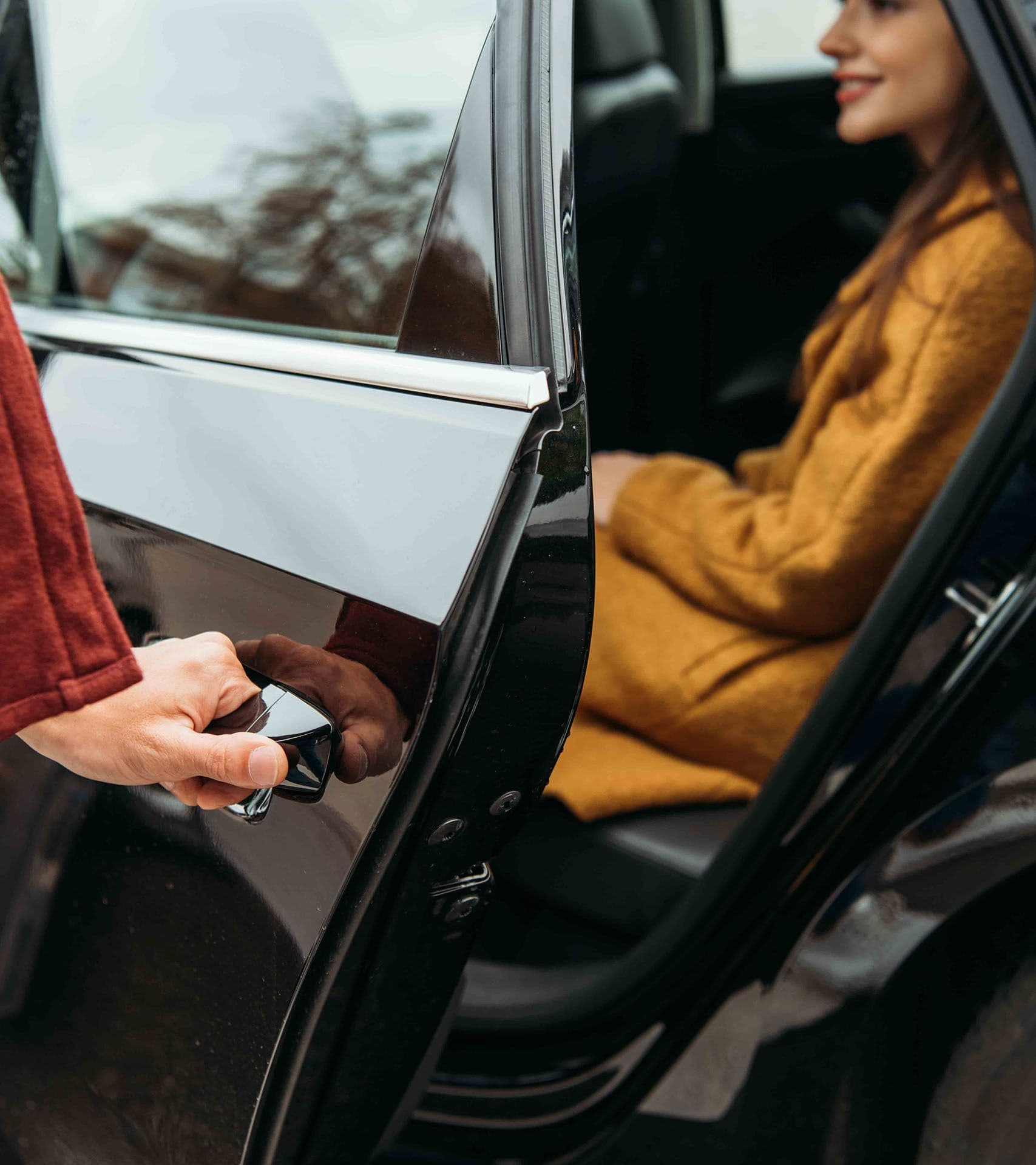 A rideshare driver opening the door for a passenger.